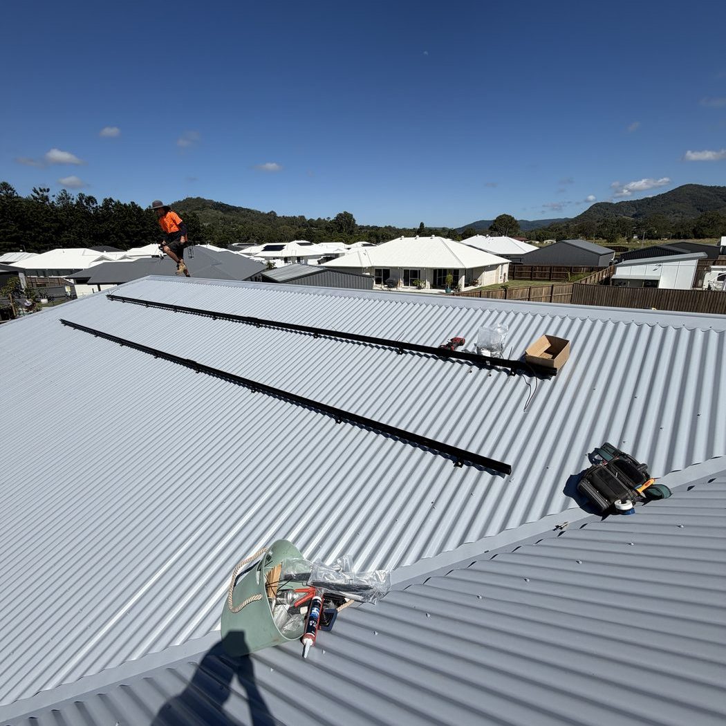 Solar panel installation in progress on a Cooroy home metal roof — Ultralec Electrical solar installer